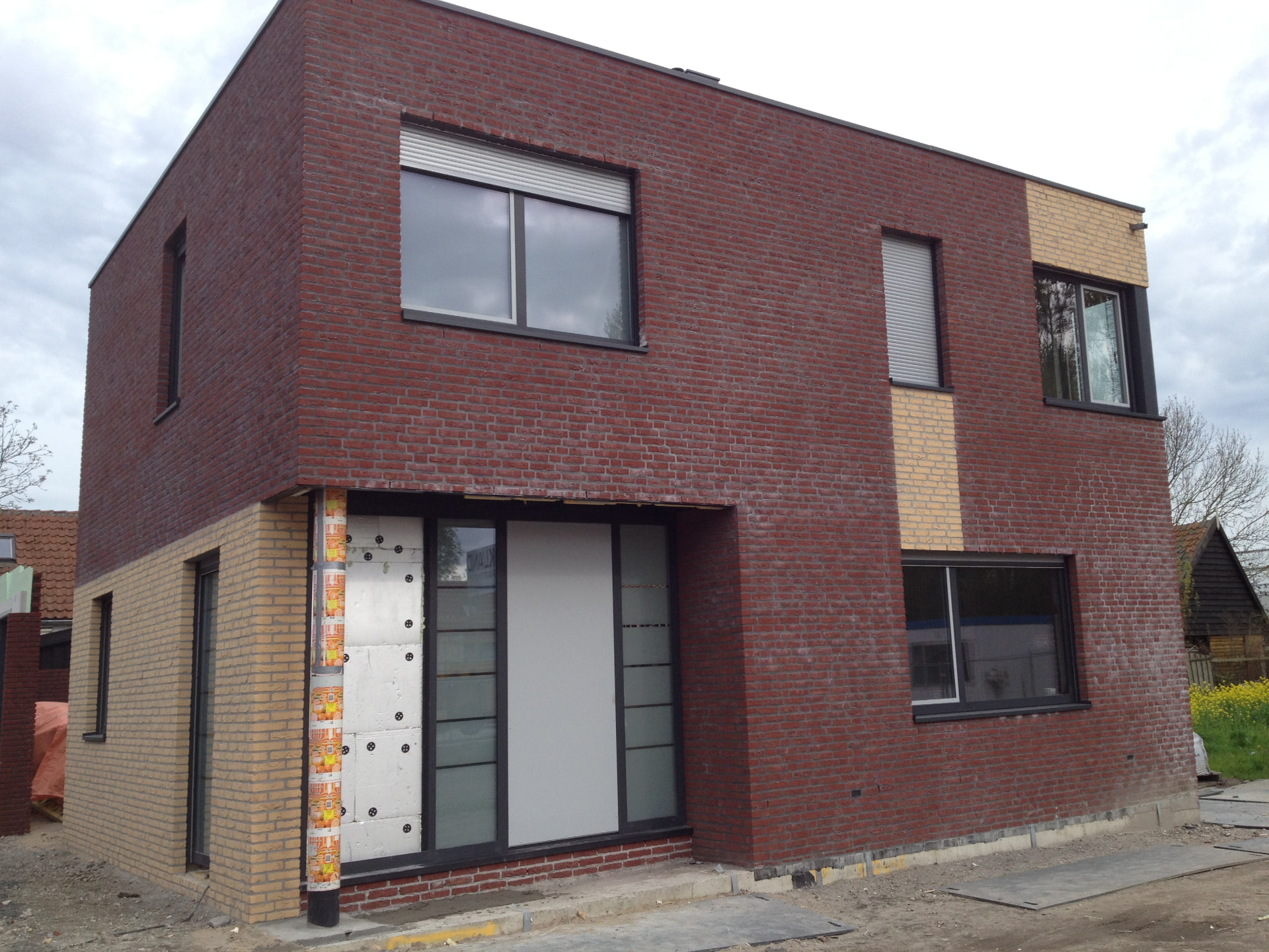 Nieuwbouw woning met rode baksteen en gele gevelsteen