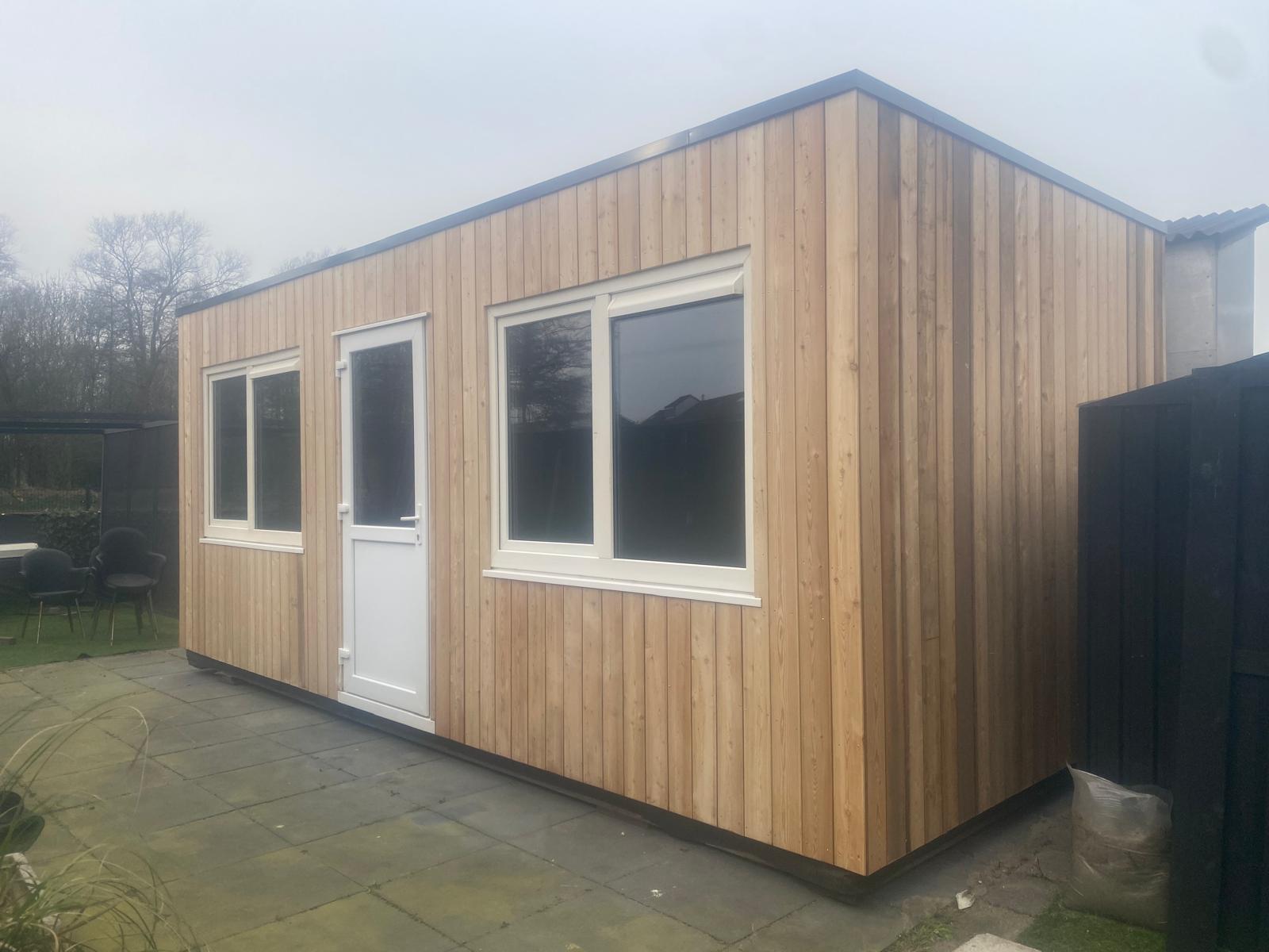Unit met verticale houten gevelbekleding in een tuin