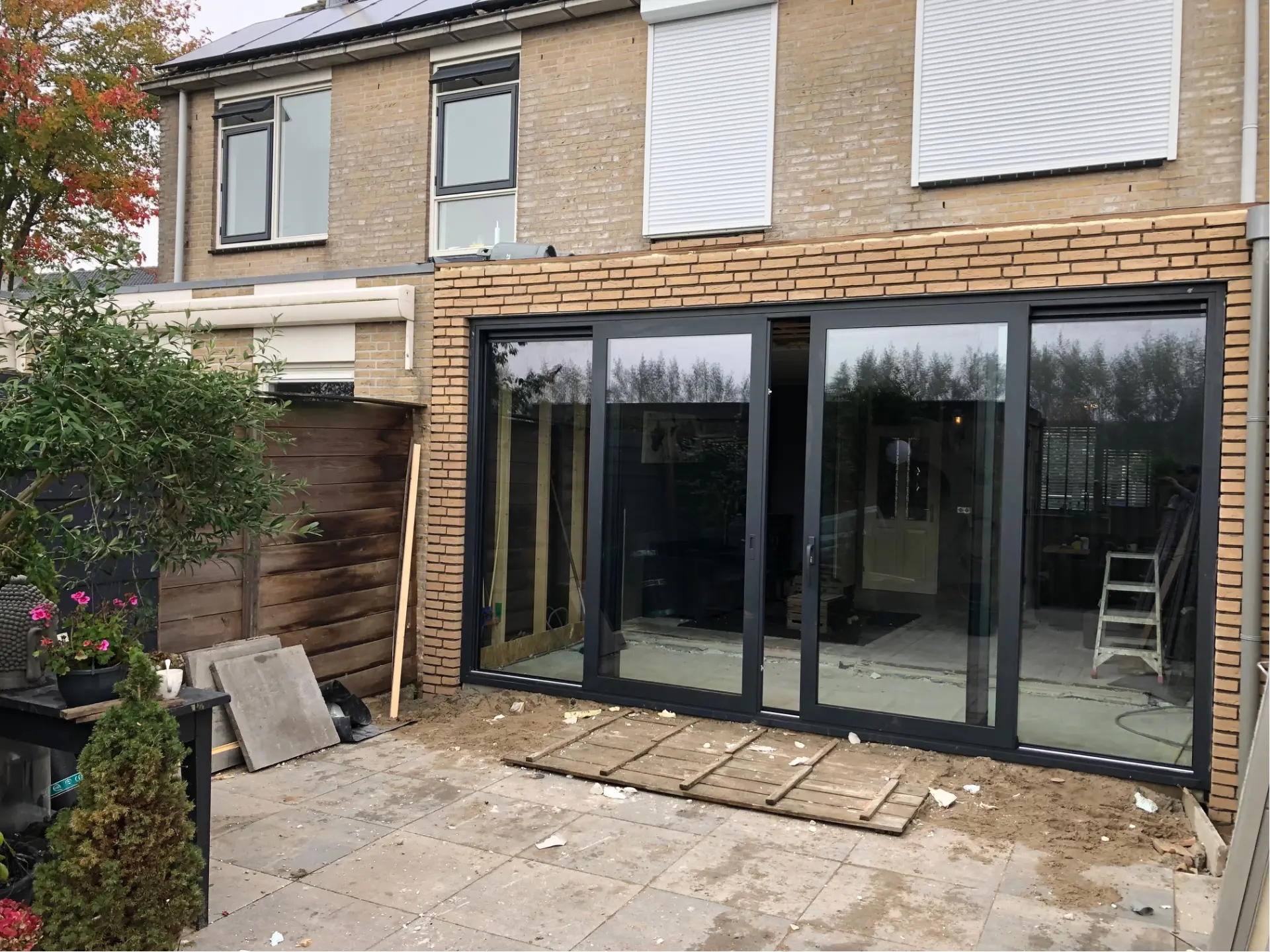 Aanbouw met brede aluminium schuifpui in antraciet aan een woning